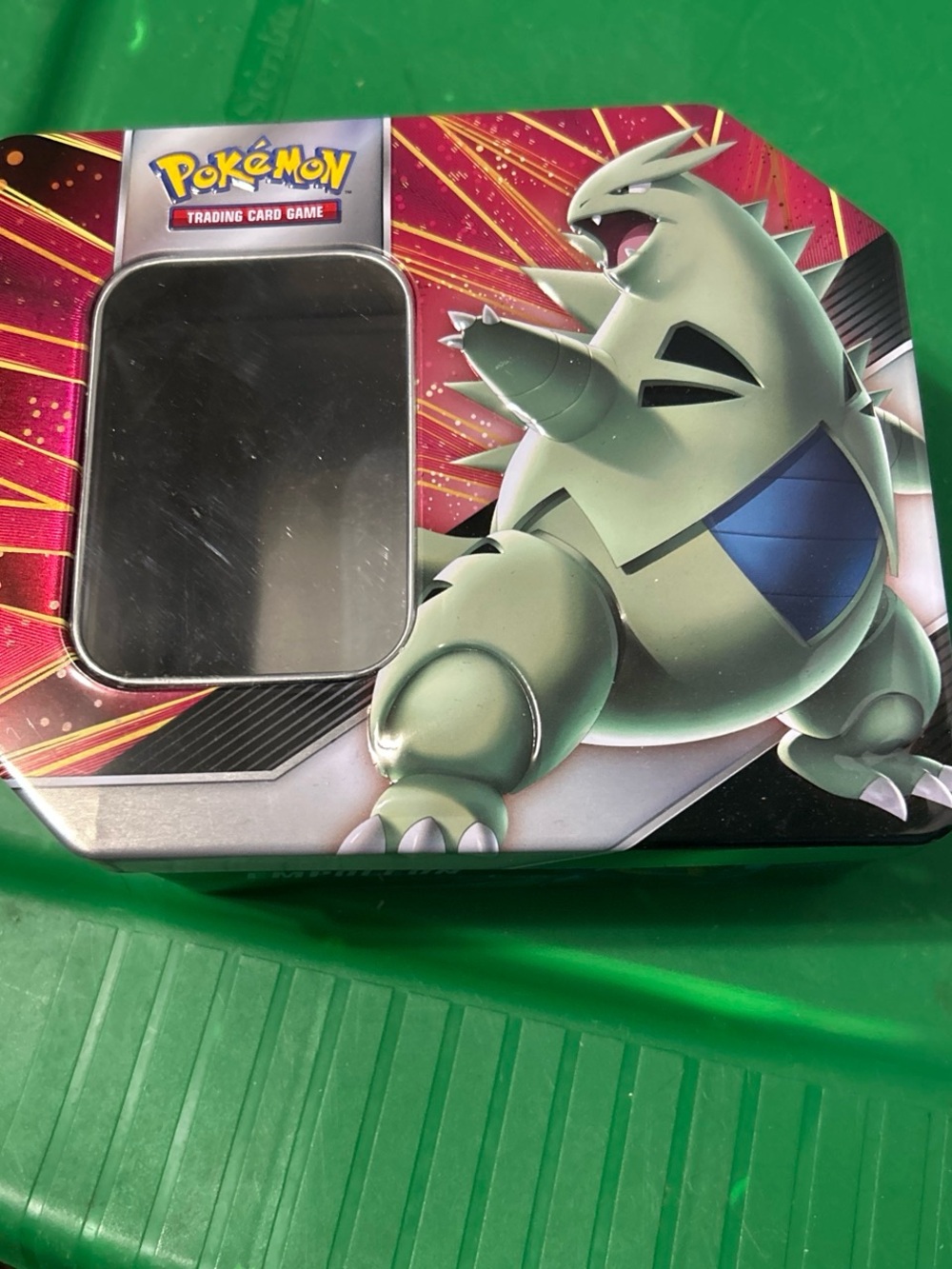 Pokemon Tin with Green Tyranitar Artwork and Red Accents